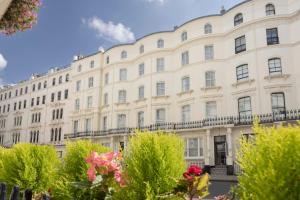 a large white building with trees in front of it at 55 by Le Mirage in London