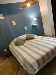 a bedroom with a bed with a blue wall at L’appart chic gapençais in Gap