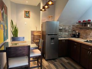 a kitchen with a stainless steel refrigerator and a table at DEPARTAMENTO CON TERRAZA Y VISTA para 6 personas in Chihuahua
