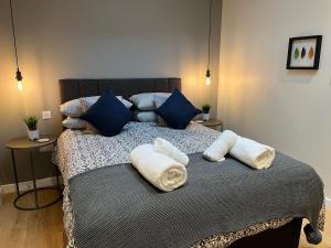 un letto con cuscini blu e asciugamani di Grayling Cottage ad Ambleside