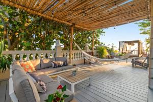 eine Terrasse mit einem Sofa und einer Hängematte auf einer Terrasse in der Unterkunft Tres Sirenas Beach Inn in Rincon