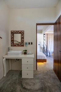 a bathroom with a sink and a mirror and a bed at Cabañas Sicarú Mazunte in Mazunte
