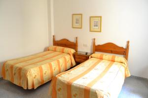 two beds in a small room with two bedsvisor at Hostal Centro Ejido in El Ejido