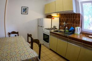 kuchnia ze stołem, lodówką i zlewem w obiekcie Apartment Pag 532b w mieście Pag