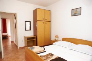 a bedroom with a large bed and a wooden cabinet at Apartment Mandre 523b in Kolan