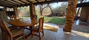 a wooden table and chairs on the porch of a house at Nature Rest in Marloth Park