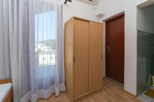 a bedroom with a wooden cabinet and a window at Studio Podaca 516d in Podaca