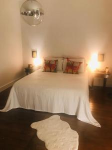- une chambre avec un grand lit blanc et deux lampes dans l'établissement 17th Century Manor with Private Pool, à Saint-Germain-les-Belles