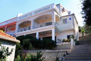 a large white house with stairs in front of it at Apartments by the sea Prigradica, Korcula - 544 in Blato