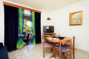 ein Wohnzimmer mit einem Tisch und einem TV in der Unterkunft Apartments by the sea Prigradica, Korcula - 544 in Blato