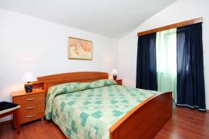 ein Schlafzimmer mit einem Bett, einer Kommode und einem Fenster in der Unterkunft Apartments by the sea Prigradica, Korcula - 544 in Blato