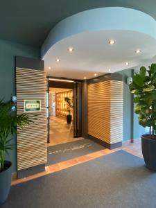 an office lobby with wooden doors and plants at Alevic Hotel Sirmione in Sirmione