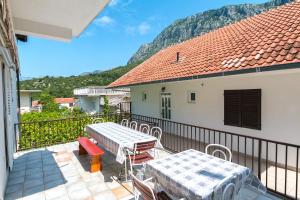 a balcony with tables and chairs and a mountain at Apartments by the sea Podaca, Makarska - 516 in Podaca