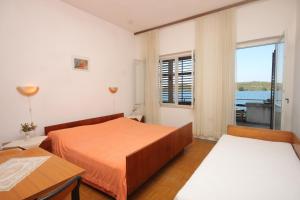 a bedroom with two beds and a window at Apartments by the sea Luka, Dugi otok - 441 in Luka