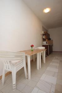 Luka的住宿－Apartments by the sea Luka, Dugi otok - 441，白色餐桌和两把白色椅子