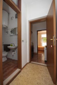 a bathroom with a toilet and a sink and a door at Apartments and rooms by the sea Luka, Dugi otok - 441 in Luka