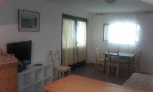 sala de estar con mesa, TV y comedor en Apartments by the sea Basina, Hvar - 542, en Vrbanj