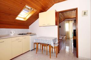 une cuisine avec des placards blancs et une table dans l'établissement Apartments by the sea Basina, Hvar - 542, à Vrbanj