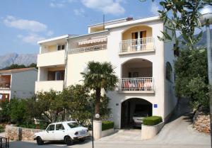 a white car parked in front of a building at Apartment Podgora 518d in Podgora