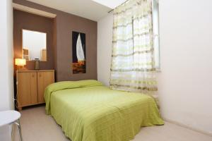 sypialnia z zielonym łóżkiem i oknem w obiekcie Apartments by the sea Korcula - 549 w Korčuli