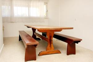 drewniany stół z ławką obok niego w obiekcie Studio Zavalatica 547a w mieście Zavalatica