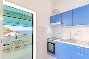 kuchnia z niebieskimi szafkami i widokiem na ocean w obiekcie Studio Zavalatica 547a w mieście Zavalatica