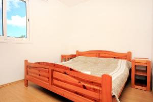 uma cama de madeira num quarto com uma janela em Apartments by the sea Zavalatica, Korcula - 546 em Zavalatica