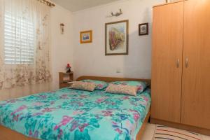 a bedroom with a bed and a wooden cabinet at Apartments by the sea Grebastica, Sibenik - 461 in Grebaštica