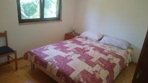 a bedroom with a bed with a purple and white quilt at Apartments with a parking space Zman, Dugi otok - 449 in Žman