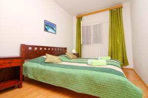 グレバシュティツァにあるApartments by the sea Grebastica, Sibenik - 480のベッドルーム1室(ベッド2台、緑のシーツ、窓付)