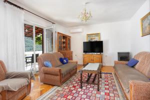 uma sala de estar com dois sofás e uma televisão em Apartments by the sea Grebastica, Sibenik - 471 em Grebaštica