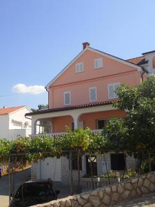 a pink house with trees in front of it at Apartment Vantacici 427d in Malinska +15 photos