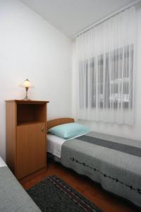 a bedroom with two beds and a dresser and a window at Apartment Vantacici 427d in Malinska