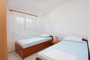um quarto com 2 camas e uma janela em Apartments by the sea Grebastica, Sibenik - 471 em Grebaštica