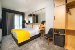 a hotel room with a bed and a yellow blanket at Trip Park Hotel in Istanbul