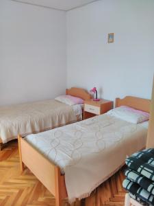 a room with two beds in a room with wooden floors at Apartments by the sea Sali, Dugi otok - 444 in Sali