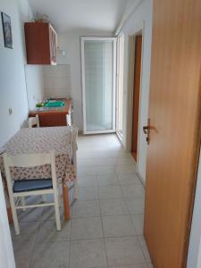 a kitchen with a table and a table and a door at Apartments by the sea Sali, Dugi otok - 444 in Sali