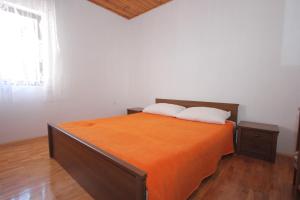 una camera da letto con un letto con lenzuola arancioni e una finestra di Apartments with a parking space Sali, Dugi otok - 447 a Sali (Sale)