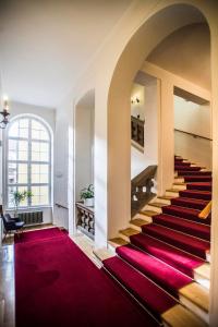 una escalera en un edificio con alfombra roja en Opitzův dům en Praga
