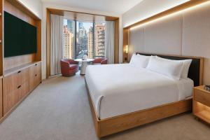 a hotel room with a large bed and a tv at Pendry Manhattan West in New York