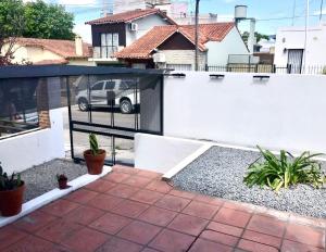 a fence with a car parked in a driveway at Duplex Gral .Viamonte 27- Tandil in Tandil