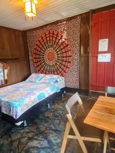 a bedroom with a bed and a table and a table and a chair at Pousada Amazônia Encantada in Iranduba
