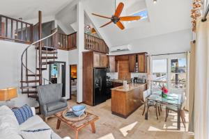 a living room with a kitchen and a spiral staircase at Tres Sirenas Beach Inn in Rincon