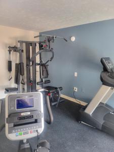 a room with a gym with a treadmill and a tv at Ramada by Wyndham Lumberton in Lumberton