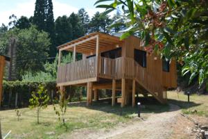 una casa de madera con terraza en un patio en Cabañas Compostela - Cabaña La Catedral con bañera de hidromasaje en Santiago de Compostela