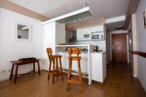 a kitchen with two wooden stools and a kitchen with a refrigerator at Tu Apart En Bariloche 34 in San Carlos de Bariloche