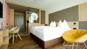 um quarto de hotel com uma cama grande e duas cadeiras em Obstgarten Gästehaus em Hollenstein an der Ybbs
