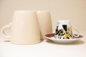 a white coffee mug and a plate with some legos at L'Otentik-Clim-Centre Historique- in Périgueux