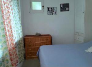 1 dormitorio con 1 cama, vestidor y ventana en Casa Vacanze sul mare, en Malfa