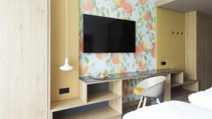 Pokój z biurkiem i telewizorem na ścianie w obiekcie Obstgarten Gästehaus w mieście Hollenstein an der Ybbs